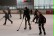 Die Schüler laufen mit Eishockeyschlägern in der Hand über das Eis.