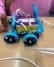 Ein Lego-Roboter-Fahrzeug fährt auf einem Tisch.
Neben dem Roboter ist eine Hand.