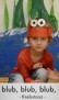 Ein Kindergartenkind mit orangenem T-Shirt hat eine Krebsverkleidung auf dem Kopf. Er hockt vor der Kulisse und macht Bewegungen eines Krebses.