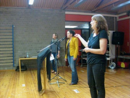 Frau Oelke-Rehbach und zwei Mitarbeiterinnen des StarkMacher-Projekts stehen vor Mikrofonen.