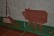 An der Wand des Kindergartenflures hängen ein gebasteltes Wildschwein und ein Frischling aus Tonpappe. Die beiden Tiere  stehen auf einem grünen Streifen Pappe mit Moos.