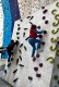 Zwei Jungen klettern ohne Seil die schräge Kletterwand hoch. 